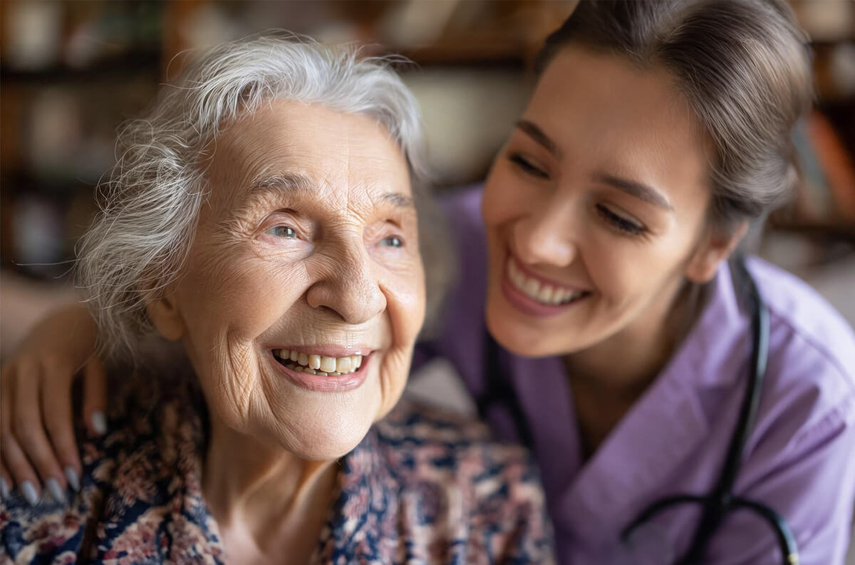 Carer helps smiling elderly lady